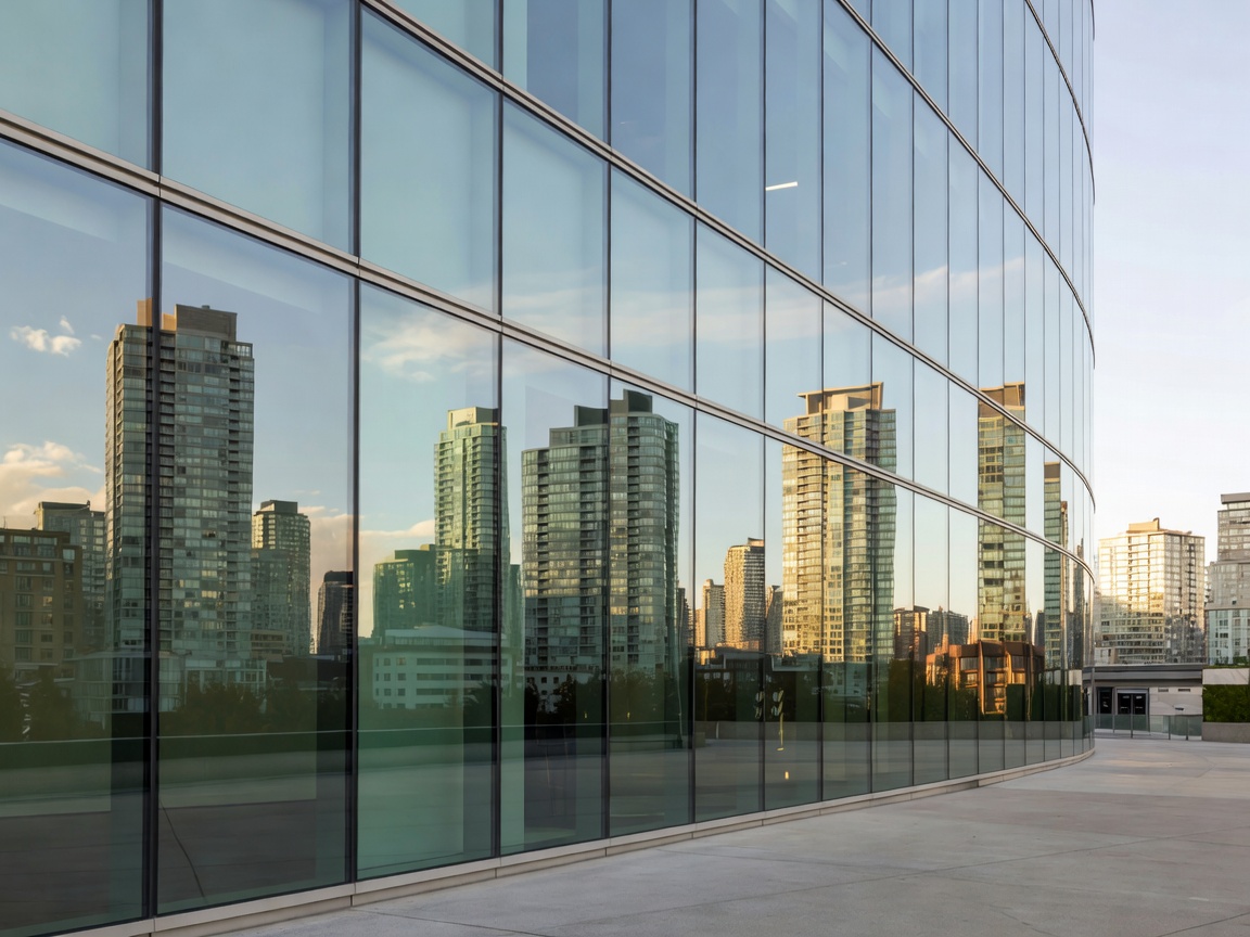 The curved glass exterior of Parq Vancouver reflecting the city skyline
